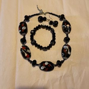 Black gemstone with splashes of white and red with earring and bracelet
